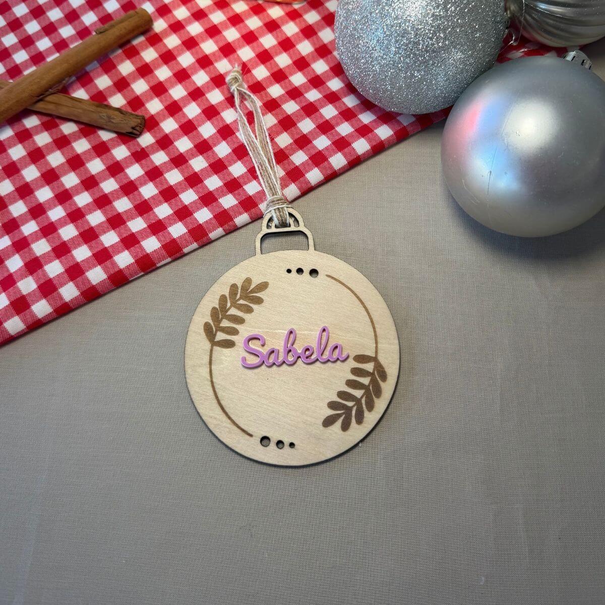 Bola de Navidad personalizada con nombre en metacrilato de color. Adorno para árbol de Navidad con hojas grabadas y nombre personalizado. Bola navideña personalizada con nombre de metacrilato. Decoración de Navidad para el árbol con nombre y diseño de hojas. Bola de Navidad con hojas grabadas y nombre en color. Adorno navideño personalizado para regalar a la familia